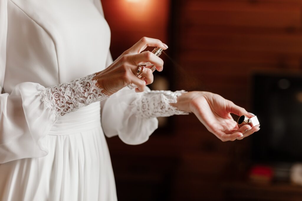 Bride hands applying perfume on her wrist, closeup selective focus. spray perfume woman applying